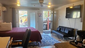 A hotel room with a bed, desk, chair, sofa, TV, and a coffee maker. - Camaray Motel (Oroville)