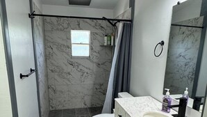 A modern bathroom with a shower, toilet, and vanity.