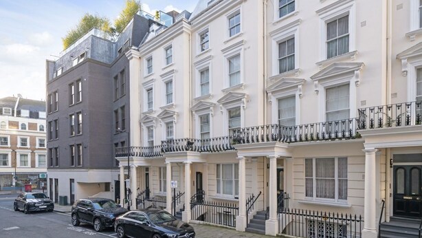 A row of traditional townhouses with a uniform facade, a central entrance, and a small balcony on the upper floor. - New 1Bed with AC near Portobello (Greater London)