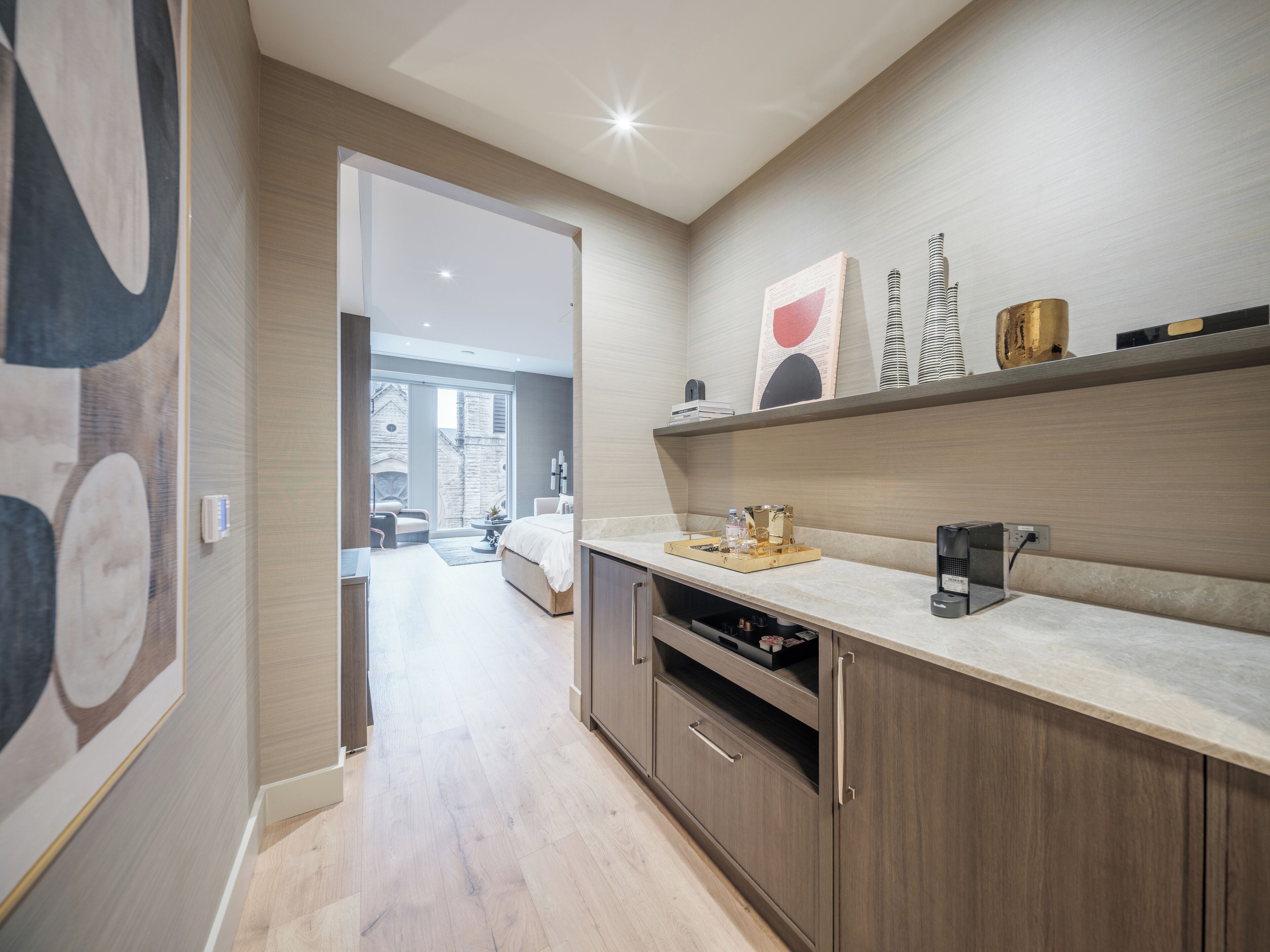 A modern kitchen with wooden cabinets, a countertop, and a view into the dining area.