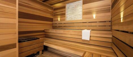 A sauna room with wooden slats, a bench, and a towel rack.