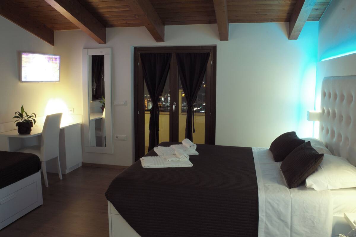 Een hotelkamer met een bed, een bureau en een televisie.