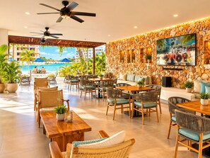 A hotel lounge with outdoor seating, a stone wall, and a view of the ocean. - Baia Kristal Prive | 2 Bedrooms | Sleeps 8 | P31L (Cartagena de Indias)