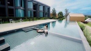 A modern building with large windows, a swimming pool, and outdoor seating. - The Posh Khao Kho (Khao Kho)