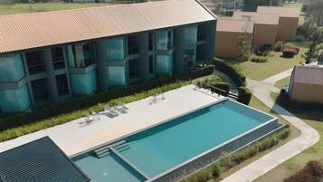 Un bâtiment moderne doté d’une piscine, d’un espace extérieur aménagé et d’une pelouse bien entretenue.