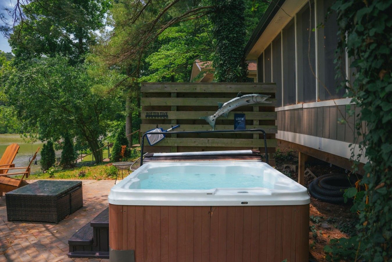 Un bain à remous avec une terrasse en bois, une clôture en bois et un panneau indiquant « ROTUR TIME ».