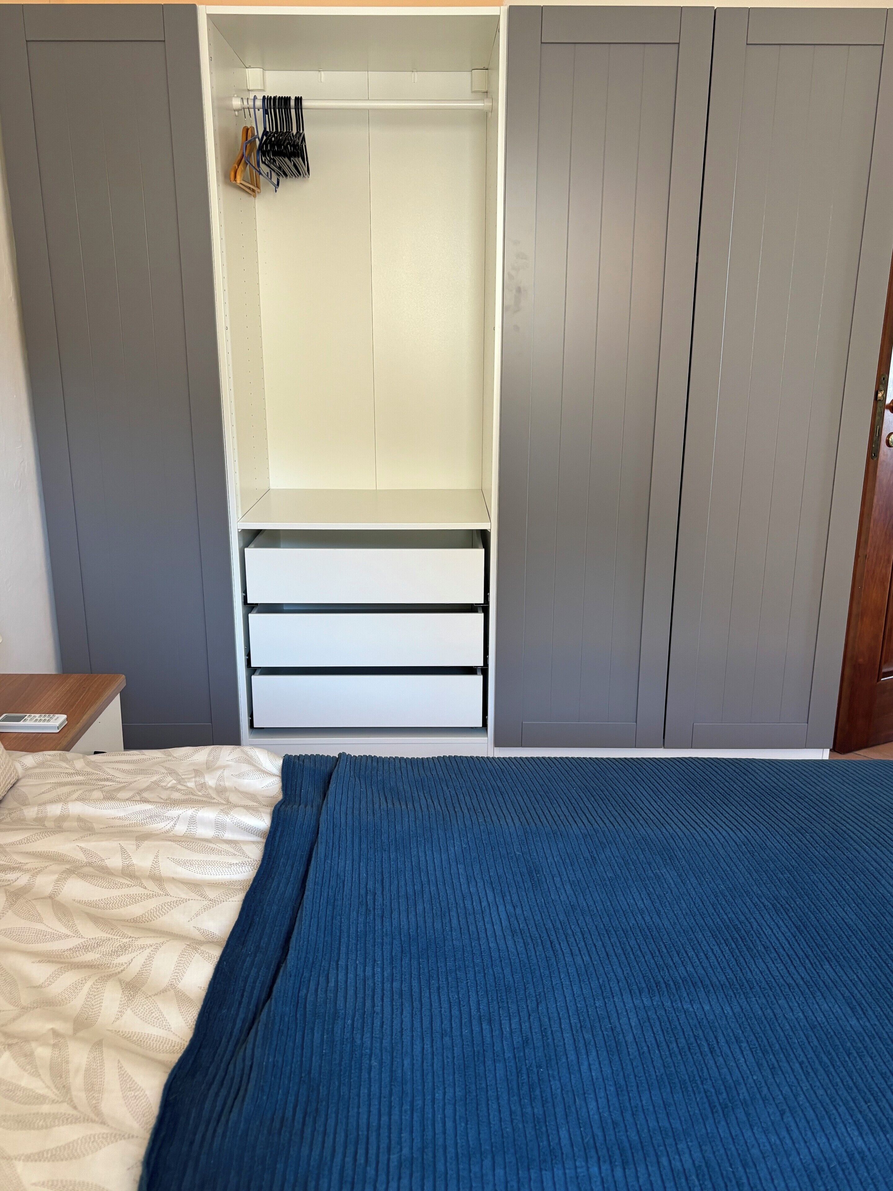 Une chambre à coucher avec un lit, une armoire et un bureau.