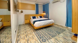 Una camera d'albergo moderna con un letto in legno, un tappeto a motivi e tende blu.