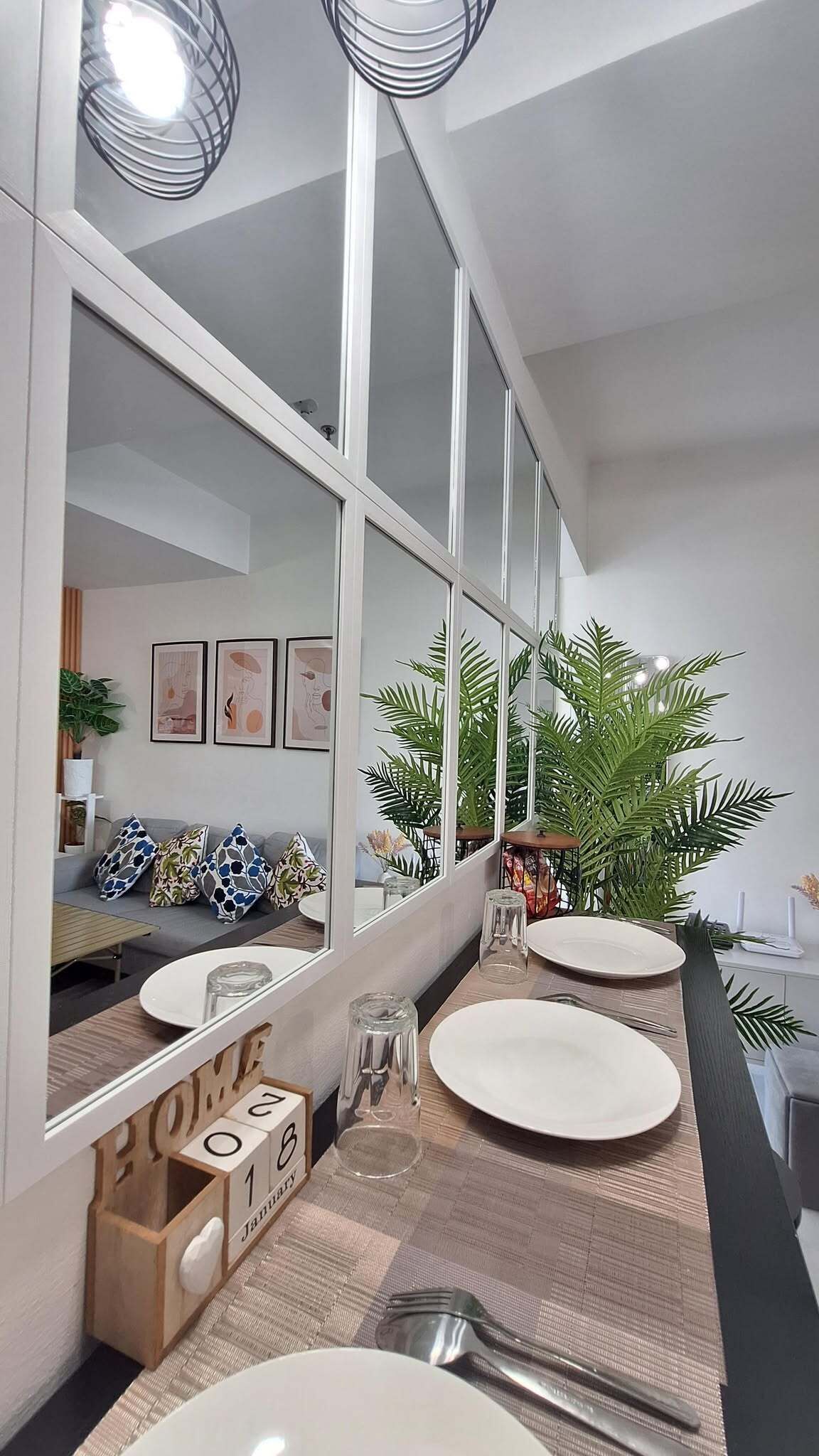 A modern bathroom with a large mirror, two sinks, and a wooden vanity.