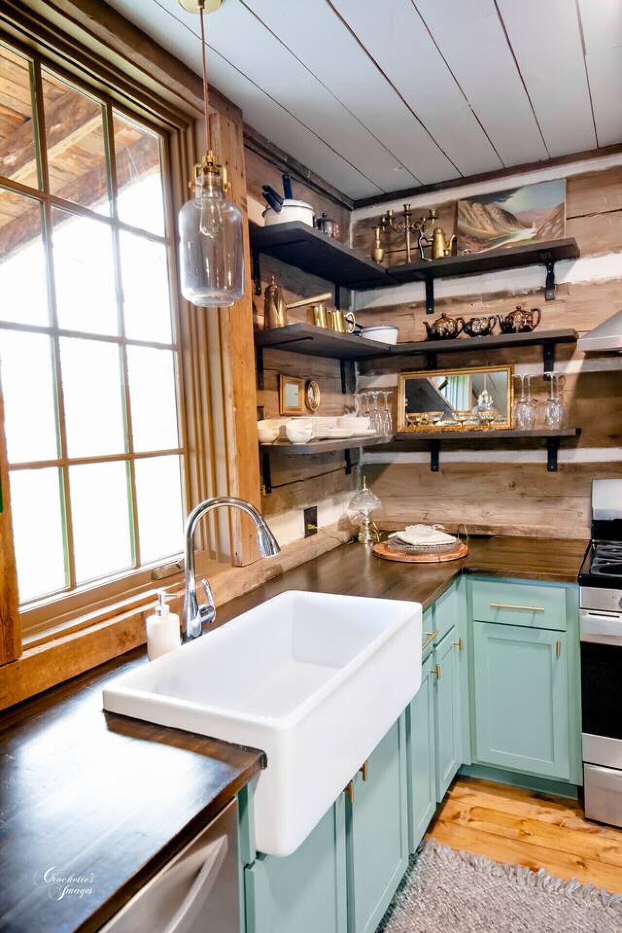 Une cuisine avec un intérieur en bois, un évier blanc et une cuisinière.