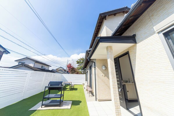 A residential backyard with artificial grass, a barbecue grill, and a patio table. - Yokkaichi Hazunaka Hotel (Yokkaichi)