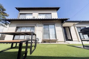 Un bâtiment à deux étages, doté d’un toit plat, de grandes fenêtres et d’une pelouse bien entretenue.