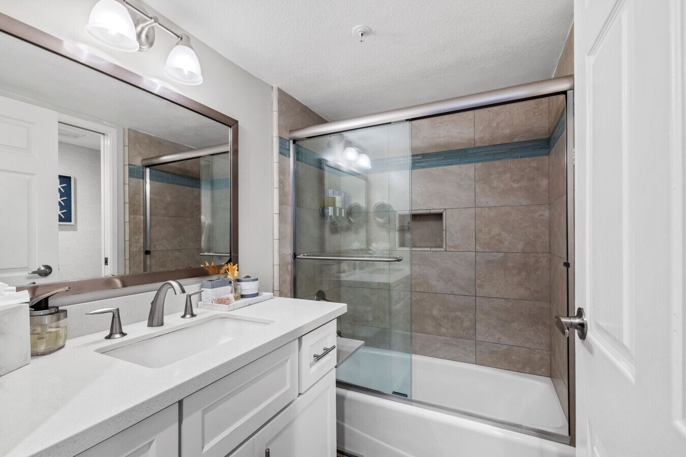 A modern bathroom with a glass-enclosed shower, a double sink vanity, and a large mirror.