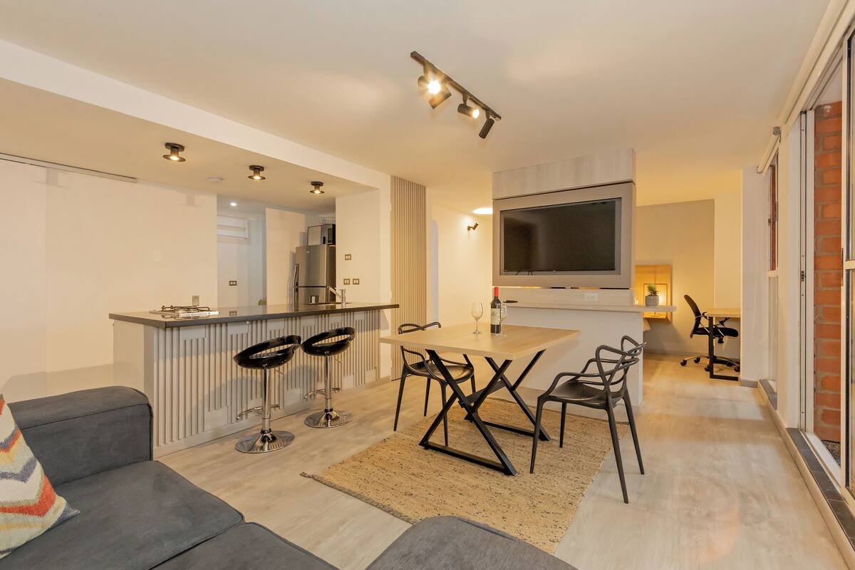 Une cuisine moderne dotée d’un îlot central, de tabourets de bar et d’une table à manger.