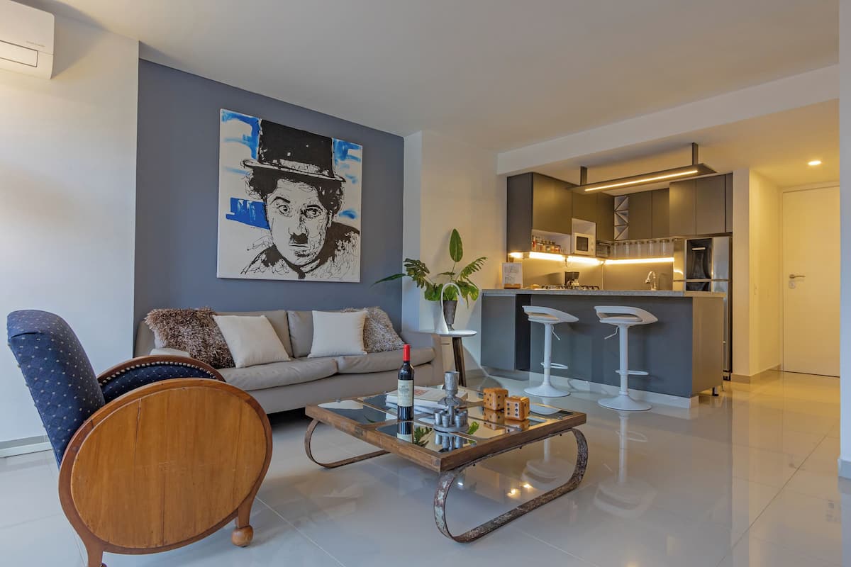 Un salon moderne avec un canapé, une table basse et un tableau au mur.