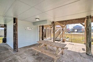 A covered outdoor area with a wooden bench and a staircase leading to a higher level. - Peace at the Beach--access to beach via walkway and blocks to drive on entrance (Surfside Beach)