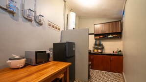 A compact kitchen with a microwave, refrigerator, and a small table with a rice cooker. - Authentic Balinese design with modern touches (Bali)
