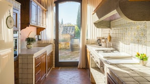 Una cocina con un ventanal grande, armarios de madera y un salpicadero de azulejos.