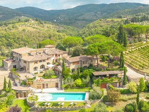 A villa with a swimming pool, surrounded by lush greenery and vineyards. - Borgo Savignola (Greve in Chianti)