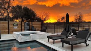 Un espace piscine doté de chaises longues et d’un jacuzzi, le tout entouré d’une clôture en bois et agrémenté d’un panneau indiquant les règles du spa.