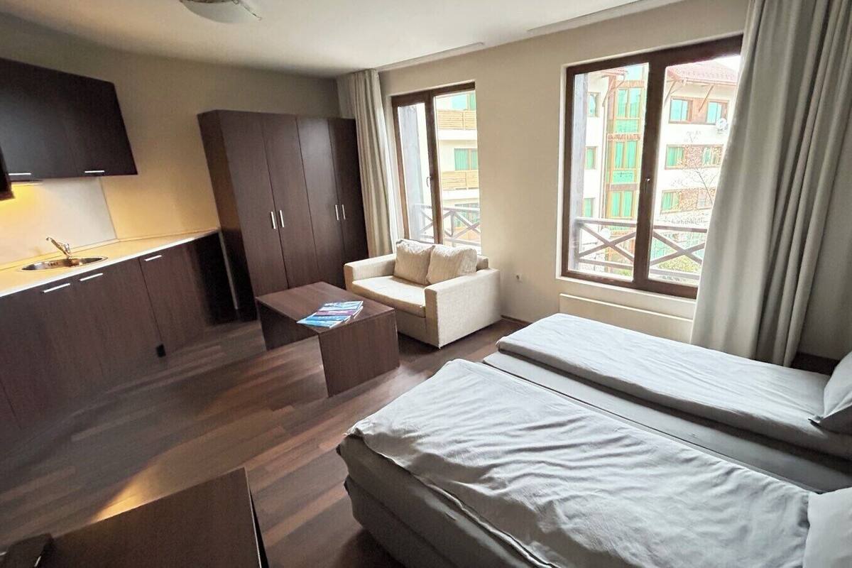 Ein Hotelzimmer mit Bett, Sofa, Schreibtisch und Fernseher.