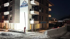 Un edificio de varios pisos con un letrero que dice 'Aspen Mountain House' y 'Apex Hotel'.