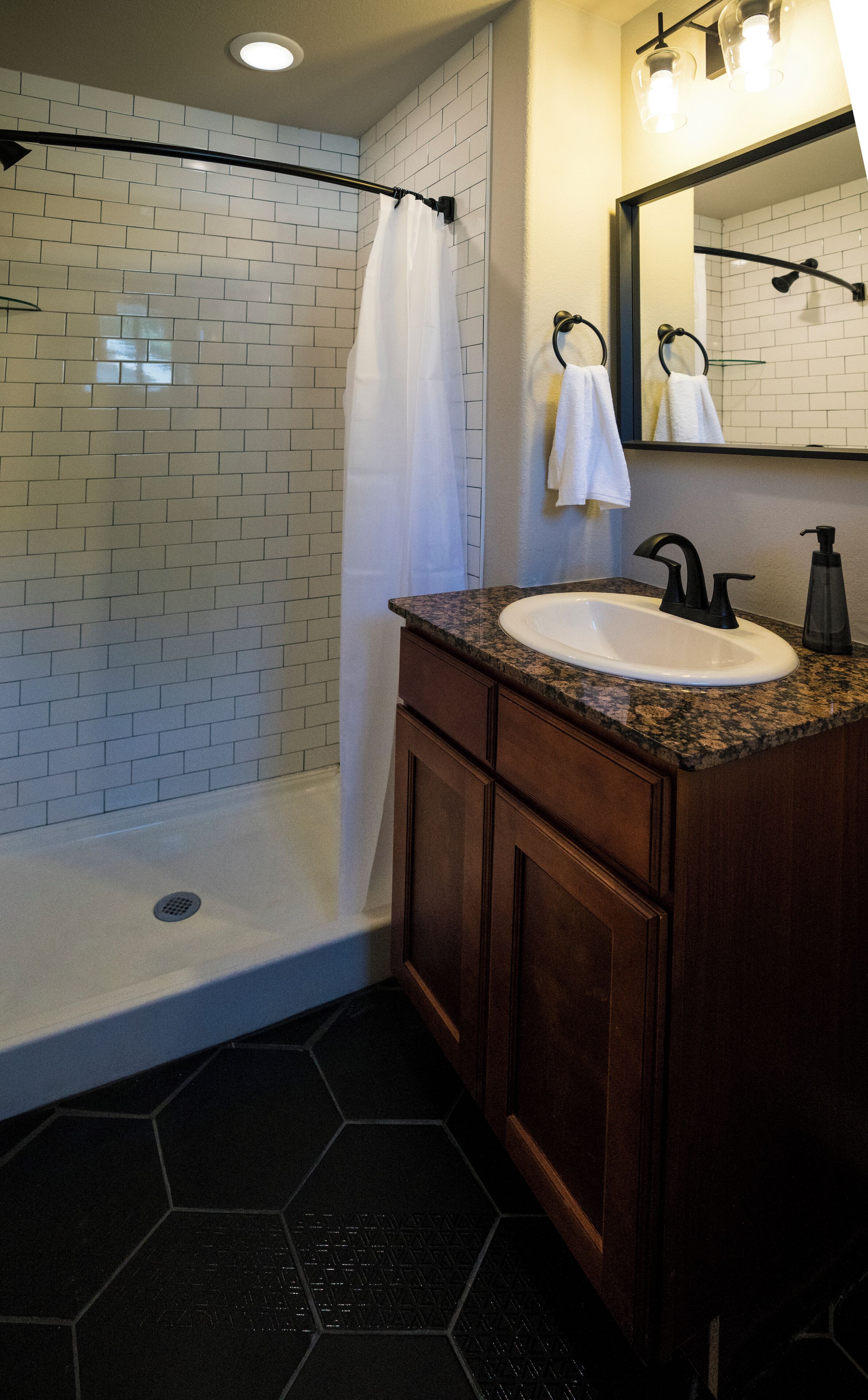 Un baño moderno con ducha, lavamanos y tocador.