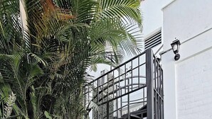 A staircase with a metal railing leading to a white building.