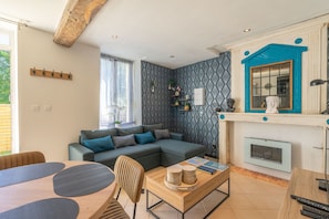 Una sala moderna con un sofá modular, una mesa de centro de madera y una chimenea.