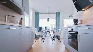 Una cocina moderna con armarios grises, encimera de madera y un comedor con mesa y sillas.
