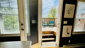 An open door leading to a wooden deck with outdoor furniture. - Cozy, Relaxing, Center City Retreat with Private Rooftop Deck! (St. John's)