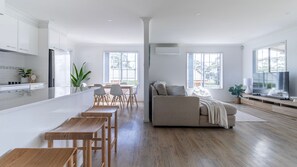 Relax in this open-plan living space with a sofa, coffee table, and dining area, perfect for socializing and meals.