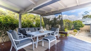 Relax in style on this serene patio surrounded by lush greenery and natural light.