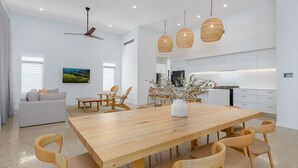 Un soggiorno moderno con zona pranzo, cucina e ventilatore a soffitto.