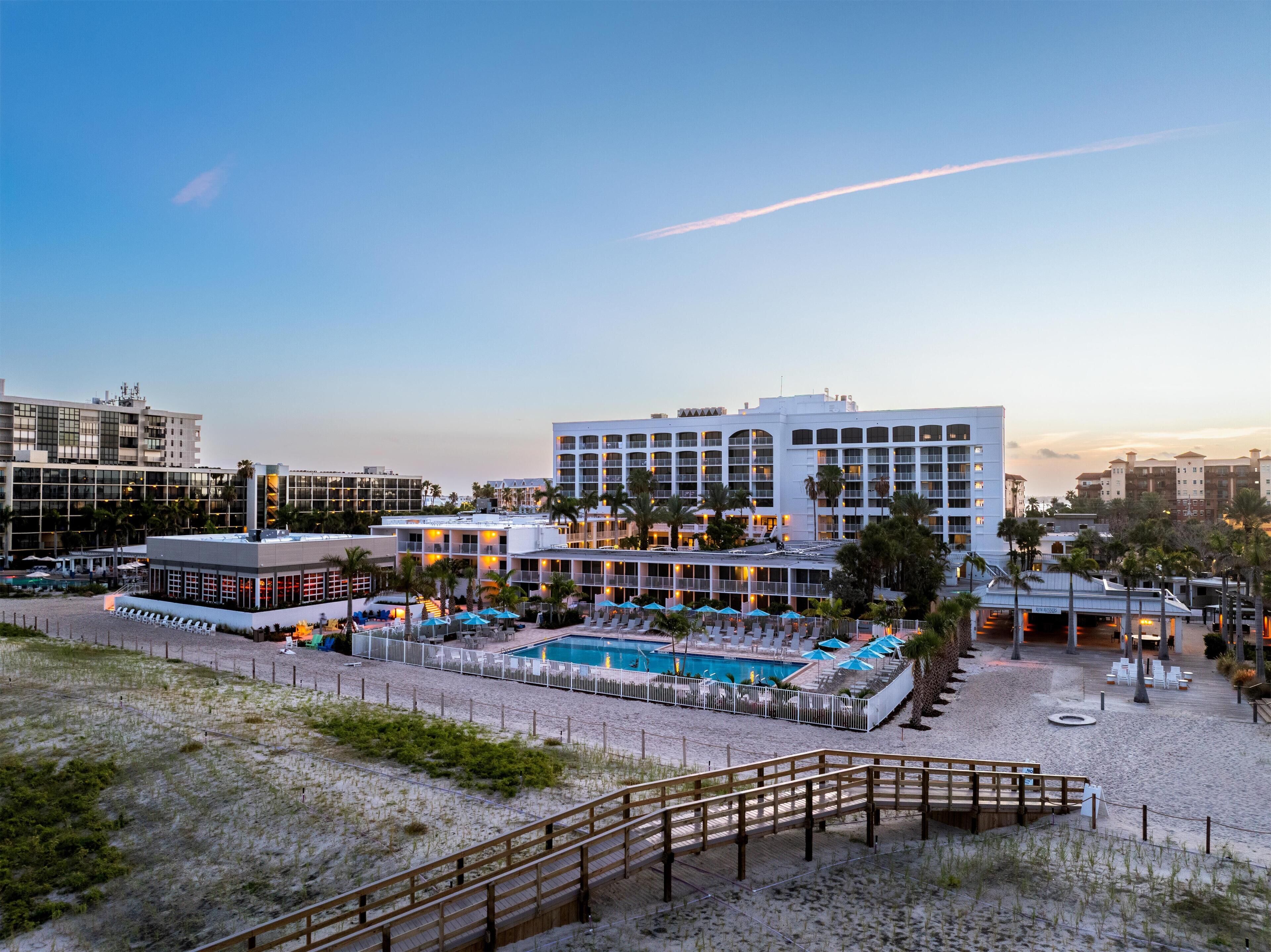 Um resort com piscina, vários edifícios e uma área de praia.