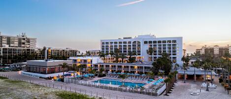 Um resort com piscina, vários edifícios e uma área de praia.