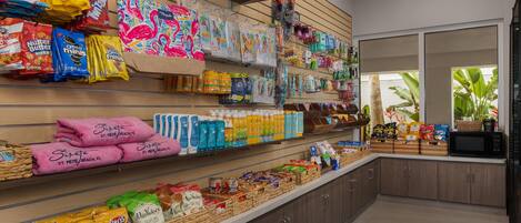 A grocery store with shelves stocked with snacks, beverages, and household items.