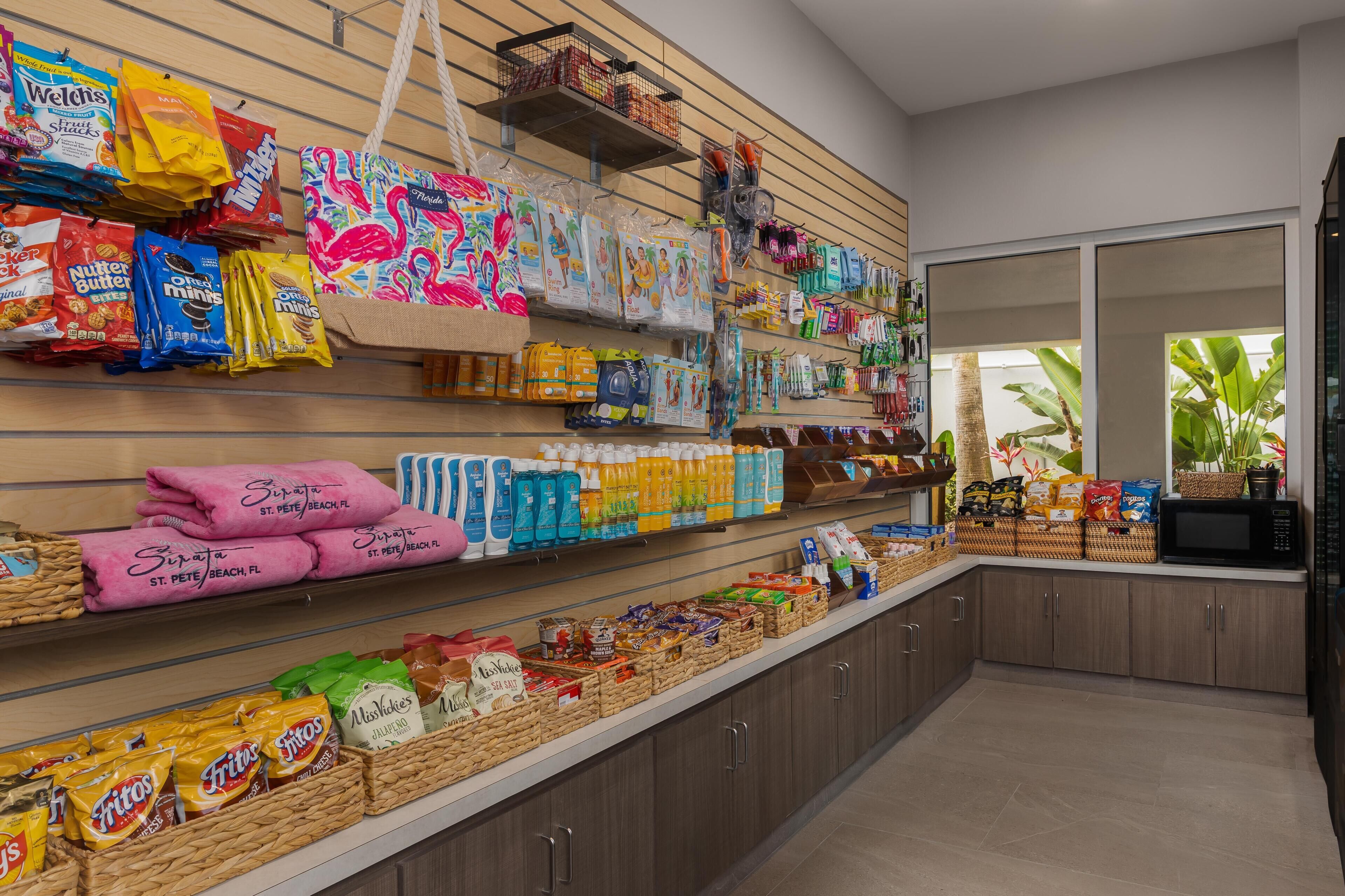 Una tienda de comestibles con estantes llenos de snacks, bebidas y artículos del hogar.
