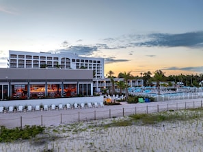 A hotel with multiple floors, outdoor seating, and a pool area. -  Sirata St. Pete Beach Resort, Tapestry Collection by Hilton (St. Pete Beach)
