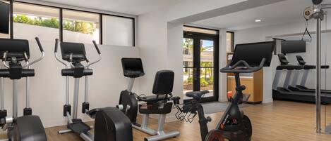 A gym with various exercise equipment, including treadmills, an elliptical, and a stationary bike.