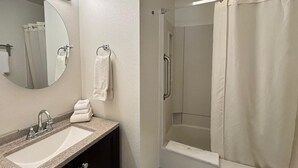A bathroom with a sink, mirror, towel rack, and a shower with a curtain. - Unit 114 - Updated Condo (Winter Park)