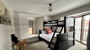 Une chambre avec un lit superposé, un bureau et une fenêtre.