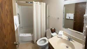 A bathroom with a toilet, sink, mirror, shower curtain, and towel rack.