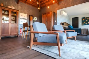 A modern living room with wooden furniture, a dining area, and a kitchen visible through an open door. - Pousada Borghetto (Bento Gonçalves)