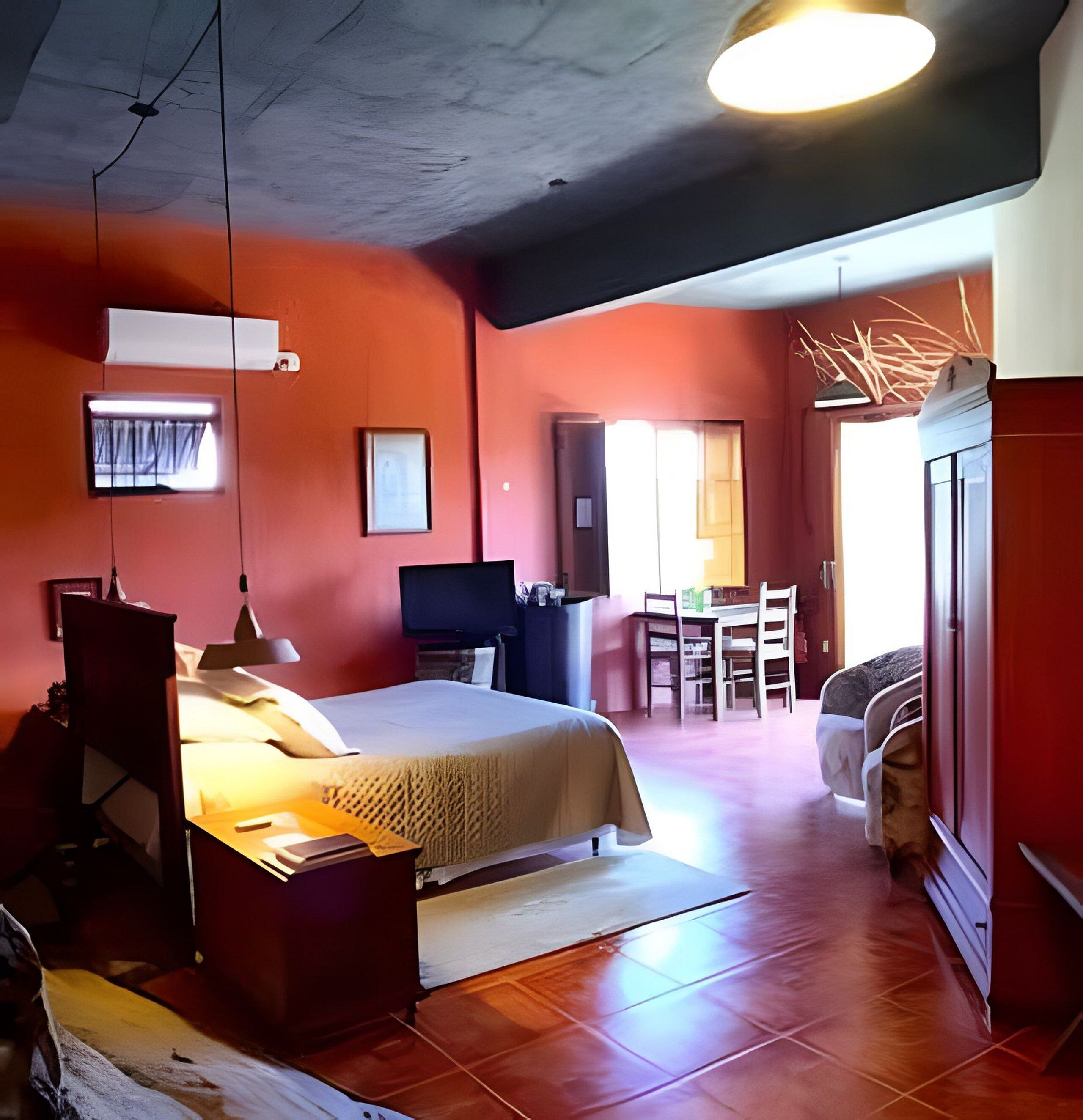 A bedroom with a bed, bedside table, and a desk with a chair.