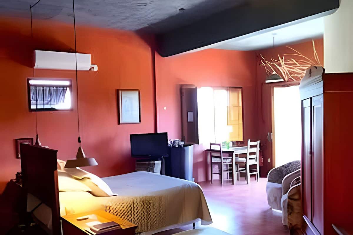 A bedroom with a bed, bedside table, and a desk with a chair.