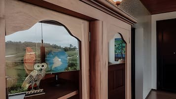Una habitación con un ventanal grande que presenta un búho decorativo y un globo terráqueo.