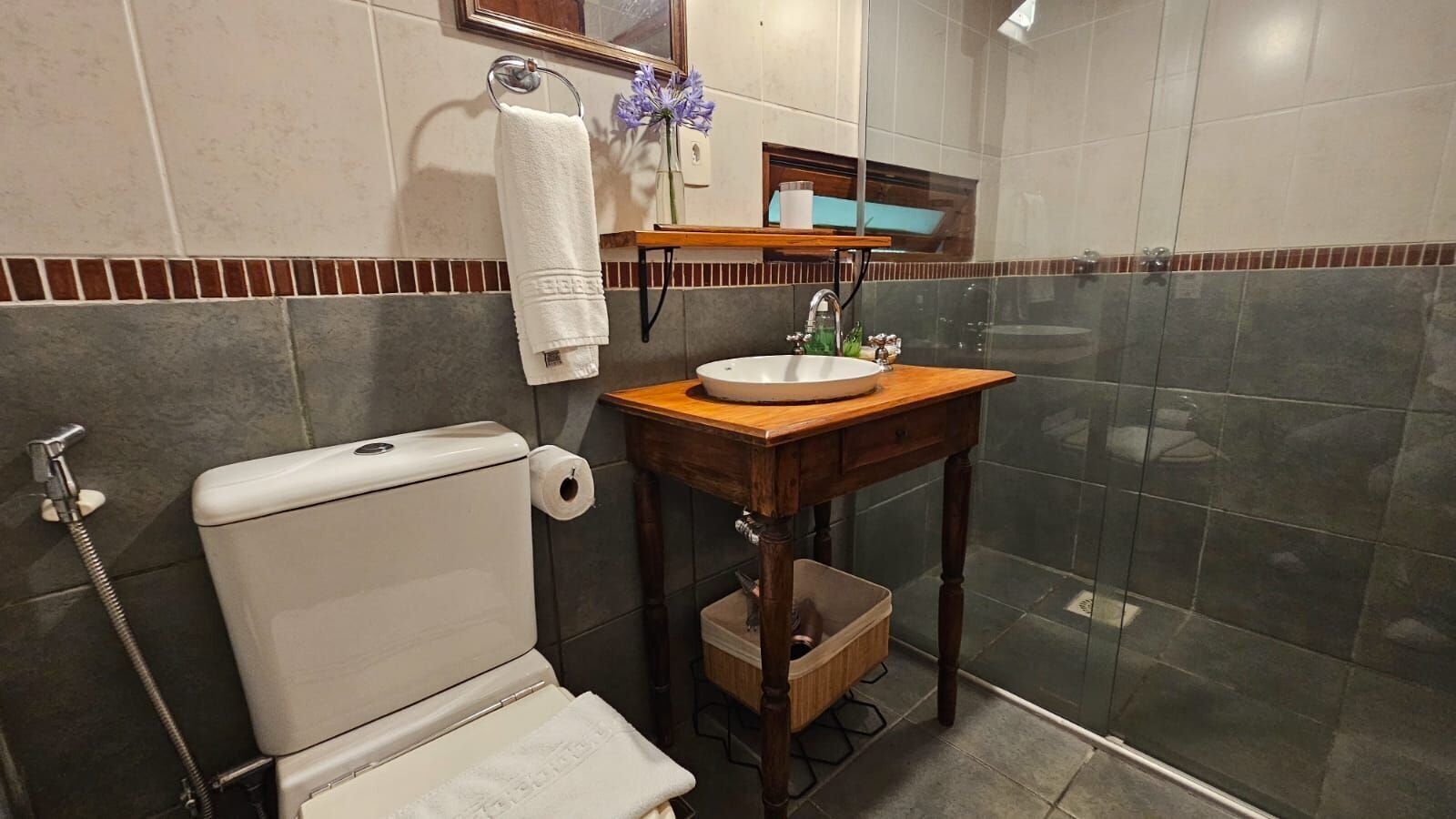 A bathroom with a toilet, sink, and shower.