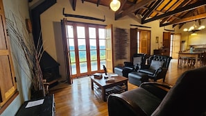 A spacious living room with a fireplace, a dining area, and a view of the outdoors. - Pousada Borghetto (Bento Gonçalves)
