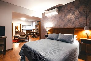 A modern bedroom with a large bed, a wooden headboard, a desk, and a chair. - Pousada Borghetto (Bento Gonçalves)